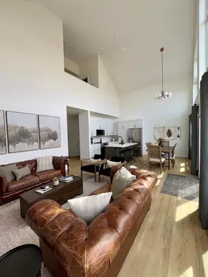 a living room with a leather couch and a table at The Lamp House in Nordegg