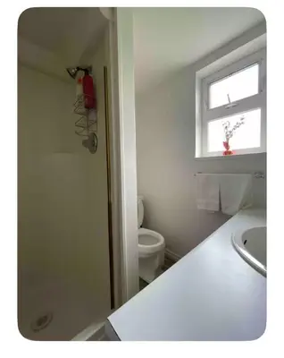 a bathroom with a toilet and a sink and a window at sweet home in Delta