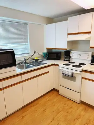 a kitchen with white cabinets and a stove and a sink at sweet home in Delta