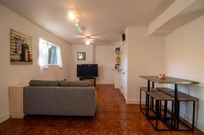 a living room with a couch and a television at Serene Garden Suite in Delta