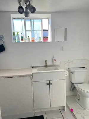 a white bathroom with a sink and a toilet at Surrey central in Surrey