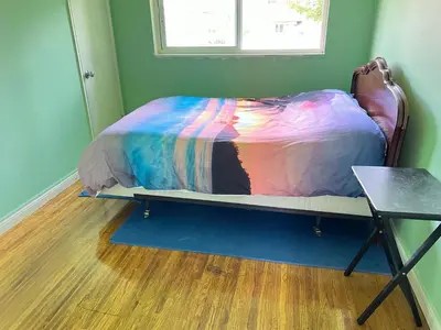 a bedroom with a bed with a colorful comforter at surrey central green bamboo house in Surrey