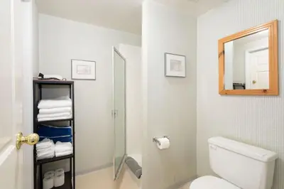 a bathroom with a toilet and a mirror and towels at Whistler Corner Loft Next to lift with Amazing views! in Whistler