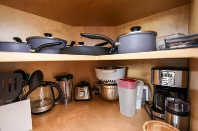 a shelf with pots and pans and other kitchen utensils at Luxury Saratoga Beach Town Home in Oyster Bay