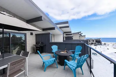 a patio with blue chairs and a table on a balcony at Luxury Saratoga Beach Town Home in Oyster Bay