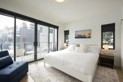 a bedroom with a large white bed and a couch at Luxury Saratoga Beach Town Home in Oyster Bay