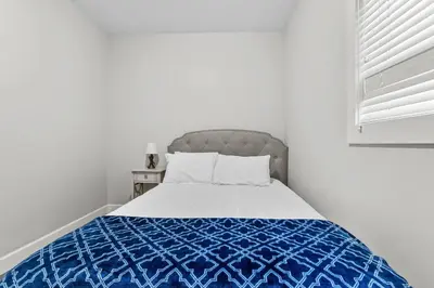 a bedroom with a bed with a blue and white comforter at Nanaimo 2BR Oceanview Suite w/ Kitchen & Laundry in Nanaimo