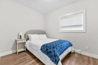 a white bedroom with a bed and a window at Nanaimo 2BR Oceanview Suite w/ Kitchen & Laundry in Nanaimo