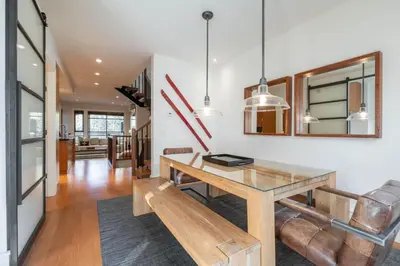 a dining room with a table and a bench at Fitzsimmons Walk 16 by Outpost Whistler in Whistler