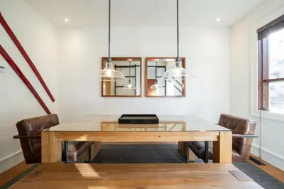 a dining room table with chairs and a mirror at Fitzsimmons Walk 16 by Outpost Whistler in Whistler