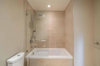a bathroom with a bath tub and a toilet at Fitzsimmons Walk 16 by Outpost Whistler in Whistler