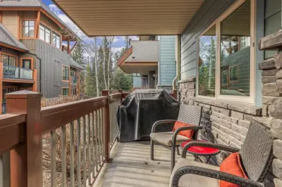 a balcony with two chairs on a house at Evergreen Escape - 2 Bedroom Condo with Pool & Hot Tub in Canmore