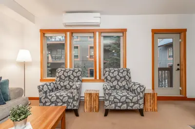 a living room with two chairs and a couch at Evergreen Escape - 2 Bedroom Condo with Pool & Hot Tub in Canmore