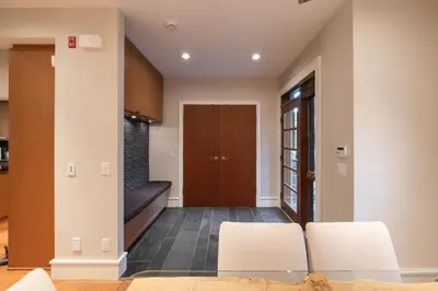a living room with a staircase and a door at Fitzsimmons Walk 21 by Outpost Whistler in Whistler