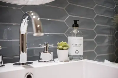 a bathroom sink with a bottle of hand soap and a plant at Fitzsimmons Walk 21 by Outpost Whistler in Whistler