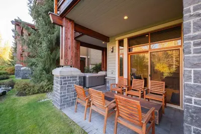 a patio with chairs and a grill on a house at Fitzsimmons Walk 21 by Outpost Whistler in Whistler