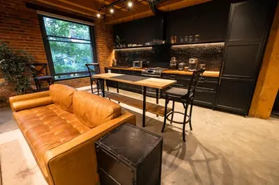 a living room with a couch and a table and a kitchen at Stylish Industrial Loft - Historic Gastown in Vancouver