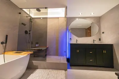 a bathroom with a shower and a sink and a mirror at Stylish Industrial Loft - Historic Gastown in Vancouver