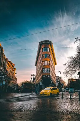 a yellow car parked in front of a tall building at Stylish Industrial Loft - Historic Gastown in Vancouver