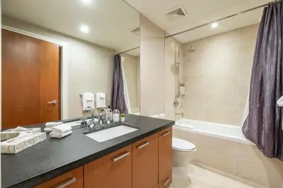 a bathroom with a sink and a toilet and a tub at Fitzsimmons Walk 26 by Outpost Whistler in Whistler