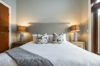 a bedroom with a large white bed with two lamps at Fitzsimmons Walk 26 by Outpost Whistler in Whistler
