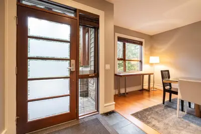 a living room with a door and a dining room table at Fitzsimmons Walk 26 by Outpost Whistler in Whistler