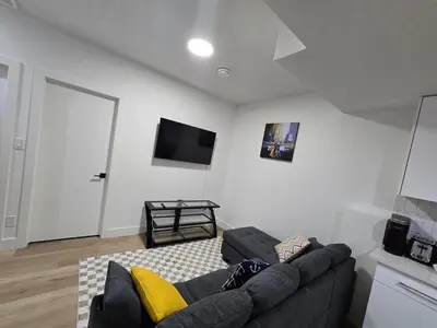 a living room with a couch and a flat screen tv at Amazing 2-bedroom house with WiFi in Edmonton in Edmonton