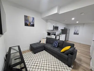 a living room with a couch and a kitchen at Amazing 2-bedroom house with WiFi in Edmonton in Edmonton