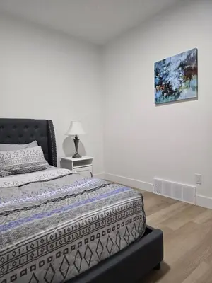 a bedroom with a bed and a painting on the wall at Amazing 2-bedroom house with WiFi in Edmonton in Edmonton