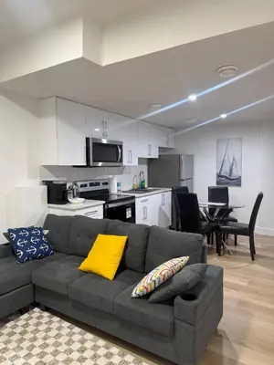 a living room with a couch and a kitchen at Amazing 2-bedroom house with WiFi in Edmonton in Edmonton