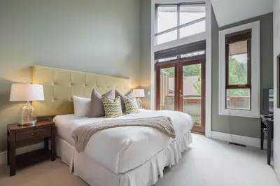 a bedroom with a large white bed and a window at Fitzsimmons Walk 35 by Outpost Whistler in Whistler