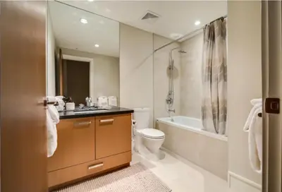 a bathroom with a toilet and a tub and a sink at Fitzsimmons Walk 35 by Outpost Whistler in Whistler