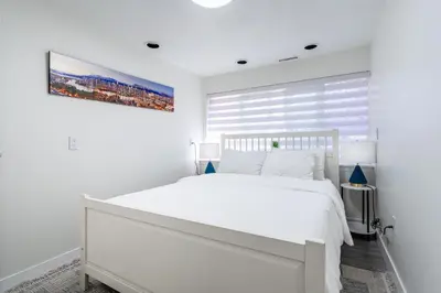a white bedroom with a white bed and a window at Spacious 3Bedrooms Family Getaway in North Vancouver in North Vancouver