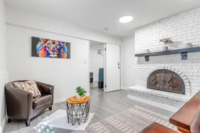 a living room with a chair and a fireplace at Spacious 3Bedrooms Family Getaway in North Vancouver in North Vancouver