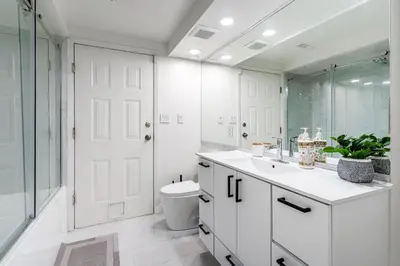 a white bathroom with a toilet and a sink at Spacious 3Bedrooms Family Getaway in North Vancouver in North Vancouver
