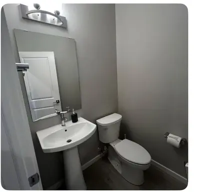 a white bathroom with a toilet and a sink at Bedroom in Southwest 2 in Edmonton
