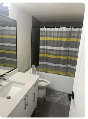 a bathroom with a sink and a shower curtain at Bedroom in Southwest 2 in Edmonton
