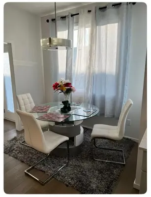 a dining room with a glass table and white chairs at Bedroom in Southwest 2 in Edmonton