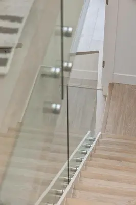 a staircase with glass railing in a building at Family-Friendly Beachside Bliss in Oyster Bay