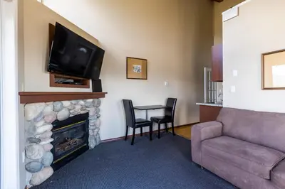 a living room with a fireplace with a tv and a couch at Radium Chalet in Radium Hot Springs