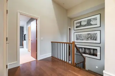 a hallway of a home with a staircase and paintings on the wall at Fitzsimmons Walk 37 by Outpost Whistler in Whistler