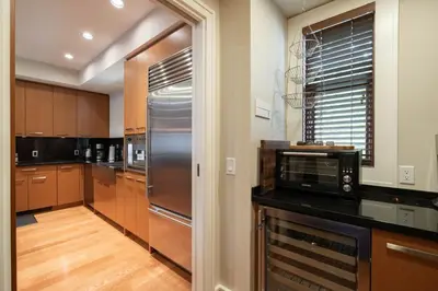 a kitchen with a stainless steel refrigerator and wooden cabinets at Fitzsimmons Walk 38 by Outpost Whistler in Whistler