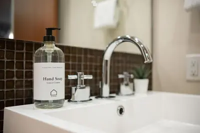 a bottle of hand soap sitting on top of a sink at Fitzsimmons Walk 38 by Outpost Whistler in Whistler