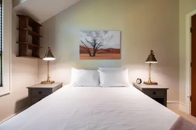 a bedroom with a large white bed with two lamps at Fitzsimmons Walk 38 by Outpost Whistler in Whistler