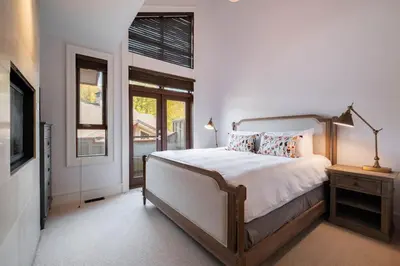 a bedroom with a bed and a tv and a window at Fitzsimmons Walk 38 by Outpost Whistler in Whistler