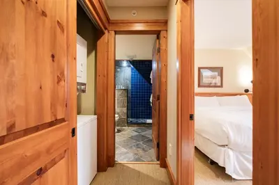 a bedroom with a bed and a bathroom with a tub at Foxglove 16 by Outpost Whistler in Whistler