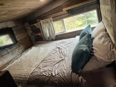 a bed in a small room with a window at Rustic Guesthouse in Sayward