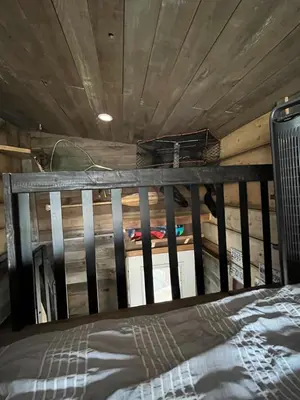 a bed in a room with a wooden ceiling at Rustic Guesthouse in Sayward