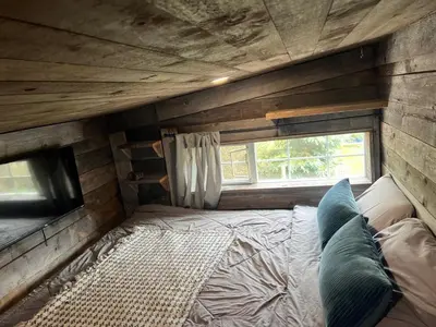 a bedroom with a bed in a room with a window at Rustic Guesthouse in Sayward