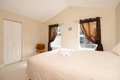 a bedroom with a large white bed and a window at 3BR 2BA Surrey Home | Quiet & Convenient in Surrey